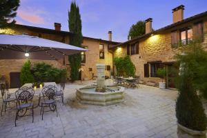 a courtyard with a fountain and tables and chairs at Le Clos Des Anges in Bagnols