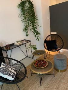 a room with two chairs and a pizza on a table at Folk by Anne Apartments & Rooms in Warsaw