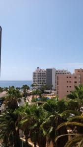 vista su una città con palme e edifici di BEACH LAS AMERICAS SUITE a Playa Fañabe