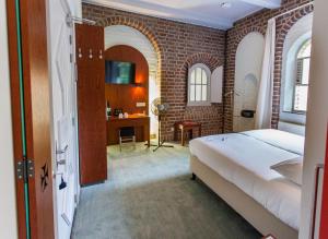 a bedroom with a bed and a brick wall at Leerhotel Het Klooster in Amersfoort
