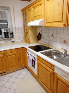 a kitchen with wooden cabinets and a sink at Ferienwohnung LAURA in Böbrach