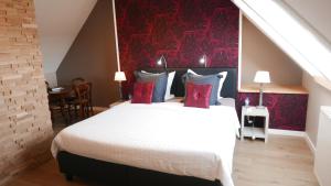 a bedroom with a large bed with a red wall at B&B Bella en Basiel in Bruges