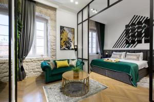 a bedroom with a green bed and a couch at DeZign Superior Apartments & Rooms in Zadar