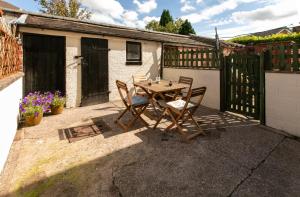 a patio with a table and chairs and a fence at Charming terraced cottage close to Alton Towers in Cheadle