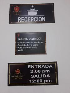 two signs on a wall with a sign for a restaurant at Hospedaje Tuuma in Fonseca