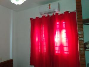a red curtain in a room with a light at Recanto das Termas, Chalés in Termas do Ibirá