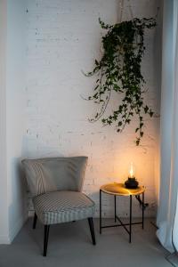 a lamp sitting on top of a table next to a plant at Folk by Anne Apartments & Rooms in Warsaw
