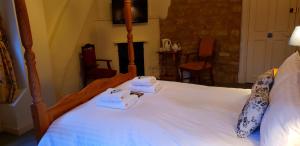 una camera da letto con un letto e asciugamani di The George Inn a Lower Brailes