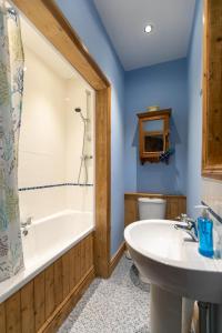 a bathroom with a tub and a sink and a toilet at Charming terraced cottage close to Alton Towers in Cheadle