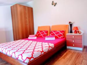 a bedroom with a bed with a red and white comforter at Peaceful View Apartment in Koper