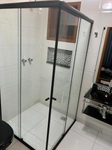 una doccia con porta in vetro in bagno di Recanto RICOROSA a Visconde De Maua