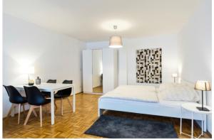 1 dormitorio con 1 cama, mesa y sillas en Ferienwohnung in Potsdam Babelsberg Nähe Berlin, en Potsdam