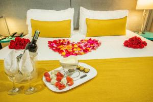 a bed with a heart made of flowers and a plate of food at Hotel City Bog 106 in Bogotá