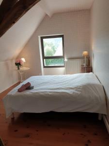 sypialnia z dużym białym łóżkiem i oknem w obiekcie La bergerie, maison spacieuse avec grand jardin, vue sur les Pyrénées w Lourdes