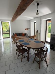 ein Wohnzimmer mit einem Holztisch und Stühlen in der Unterkunft La bergerie, maison spacieuse avec grand jardin, vue sur les Pyrénées in Lourdes