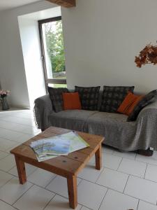 ein Wohnzimmer mit einem Sofa und einem Couchtisch in der Unterkunft La bergerie, maison spacieuse avec grand jardin, vue sur les Pyrénées in Lourdes