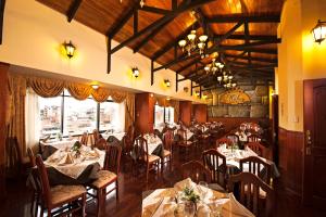 a restaurant with tables and chairs in a room at Hotel Mabey Cusco in Cusco