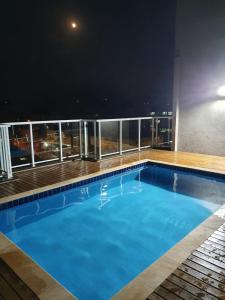 uma piscina no topo de um edifício à noite em Lindo apartamento completo em Ubatuba em Ubatuba