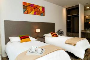 duas camas num quarto de hotel com uma bandeja de lágrimas em Magna Suites em Bahía Blanca