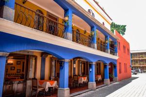 a blue building with tables and chairs on a street at Hotel Villa Española in Guatemala