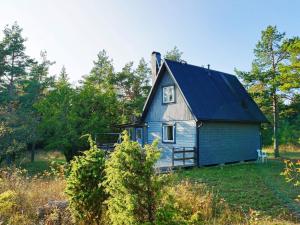 een oud blauw huis in een veld met bomen bij 4 person holiday home in L RBRO in Lärbro
