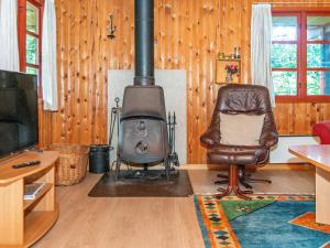 a living room with a wood stove and a chair at Three-Bedroom Holiday home in Toftlund 25 in Arrild