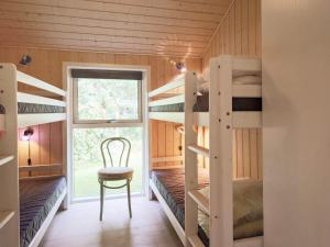 ジルレジェにあるThree-Bedroom Holiday home in Gilleleje 24の二段ベッド、椅子、窓が備わる客室です。
