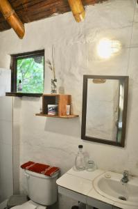 a bathroom with a toilet and a sink and a mirror at Viejamar B&B in Puerto López