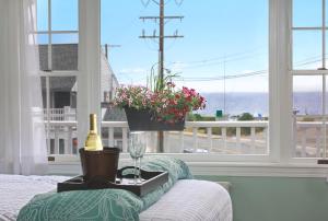 a room with a bed with a wine glass and a window at Nantasket Beach Hotel in Hull