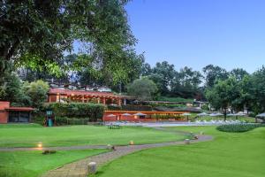 a park with a large building in the background at Hotel Avandaro Golf & Spa Resort in Valle de Bravo