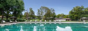 una piscina con sedie e ombrelloni di Hotel Avandaro Golf & Spa Resort a Valle de Bravo