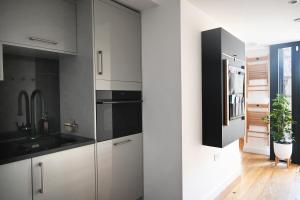 a kitchen with white cabinets and a black refrigerator at The Auld Kirk & Spa in Stirling