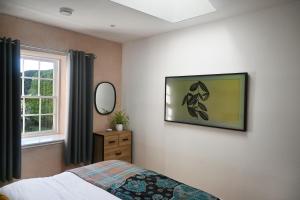 un dormitorio con una cama y una ventana en The Auld Kirk & Spa, en Stirling