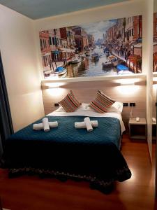 فندق دوكاله في فافارو فينيتو: غرفة نوم مع لوحة كبيرة على الحائط