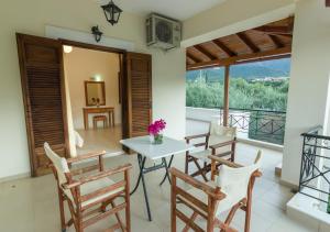 a room with a table and chairs and a balcony at Polichni in Leonidio