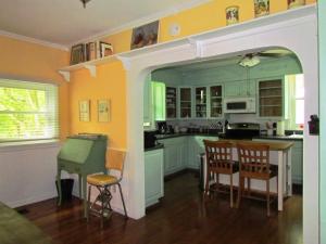 cocina con paredes amarillas, mesa y sillas en Ardendales, en Brooksville