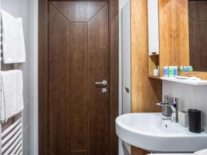 a bathroom with a sink and a wooden door at GOFD Apartman in Belgrade +7 photos