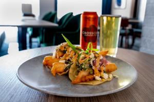 a plate of food on a table with a drink at Holiday Inn Kingston - Waterfront by IHG in Kingston