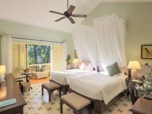 
a bedroom with a large bed and a large window at La Veranda Resort Phu Quoc - MGallery in Phú Quốc
