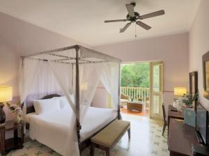 um quarto com uma cama e uma ventoinha de tecto em La Veranda Resort Phu Quoc - MGallery em Phu Quoc
