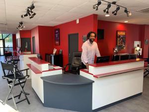 a man standing at a counter in a barber shop at Ibis Styles Paris Saint Denis La Plaine in Saint-Denis