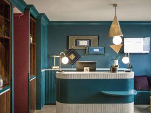 Habitación con pared azul y escritorio. en ibis Styles Paris Nation Cours de Vincennes en París