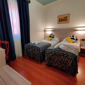 una camera d'albergo con due letti e una sedia di Hotel Ducale a Favaro Veneto