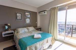 a bedroom with a bed and a large window at Departamento Tucuman in San Miguel de Tucumán
