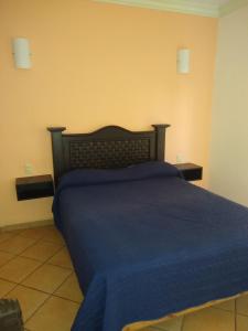 1 dormitorio con 1 cama con colcha azul en HOTEL QUINTA DEL DESCANSO, en Cuautla Morelos