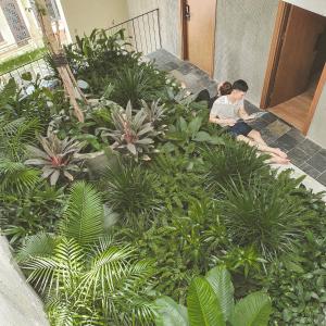 twee mensen op de trappen van een tuin bij Cagina Boutique Hostel in Dong Hoi