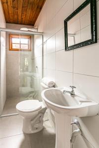 y baño con lavabo, aseo y espejo. en Vintage Apartments Florianópolis, en Florianópolis