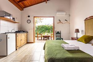 1 dormitorio con 1 cama grande y cocina en Vintage Apartments Florianópolis, en Florianópolis