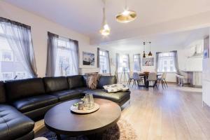 a living room with a black leather couch and a table at Superb central location, no car needed - Spacious in Akureyri