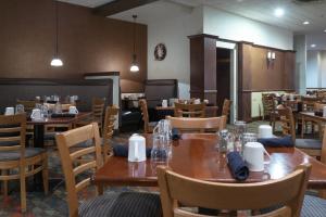 een eetkamer met houten tafels en stoelen bij Holiday Inn Harrisburg I-81 Hershey Area, an IHG Hotel in Grantville